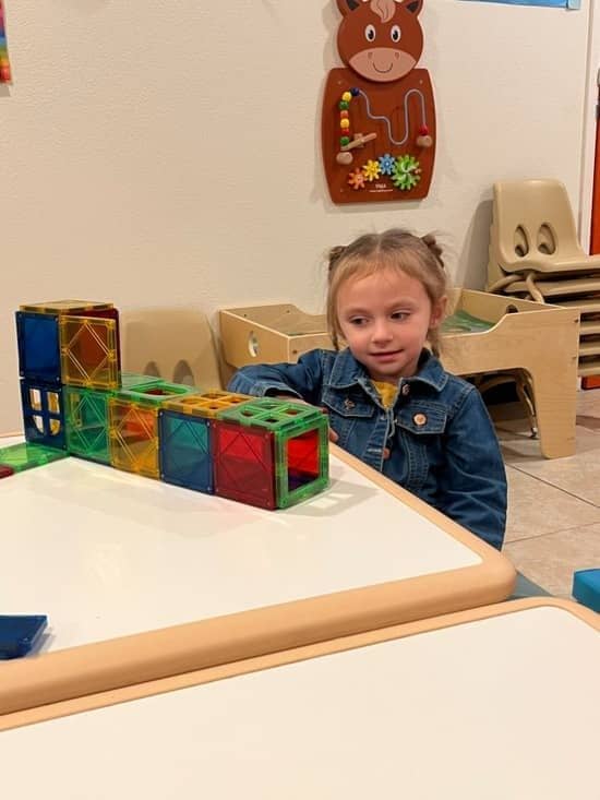 Young girl at Christian daycare center in Las Vegas building with colorful magnetic tiles.